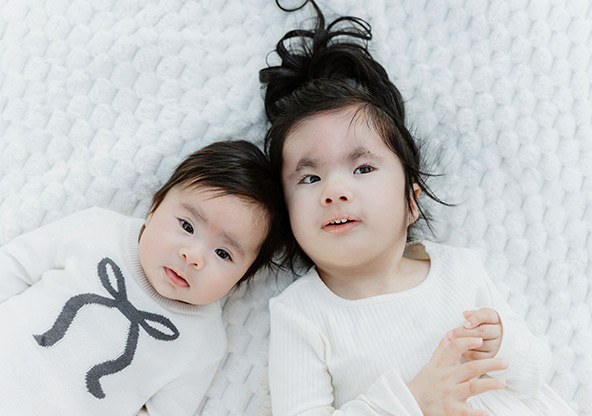 Esperanza Luna and her older sister laying next to eachother