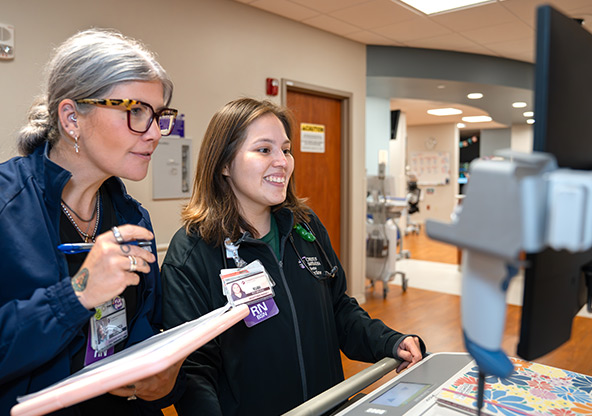 Two IMC nurses check the computer with their charts at CHRISTUS Health