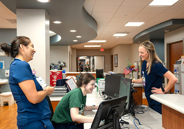 Three IMC nurses laugh together at their station