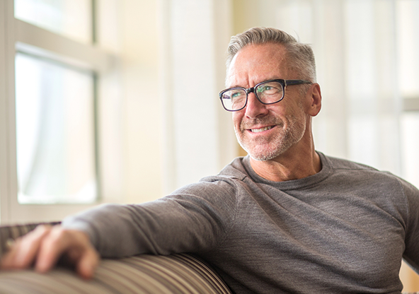A man with glasses looking out the window