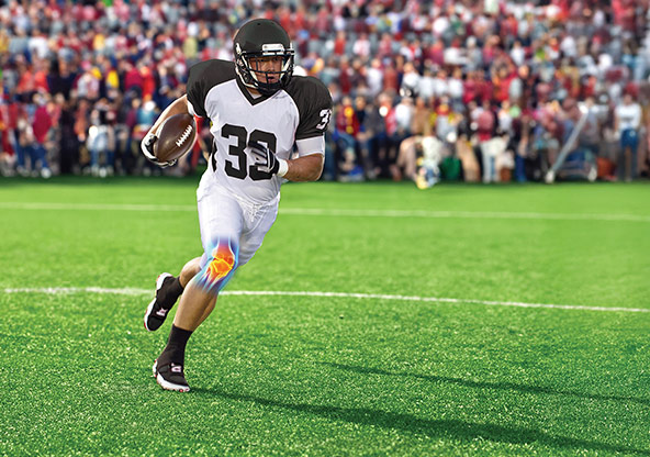a high school football player runs with the ball. His knee joint is highlighted