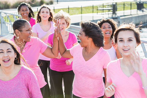 Women High Fiving on a breast cancer walk